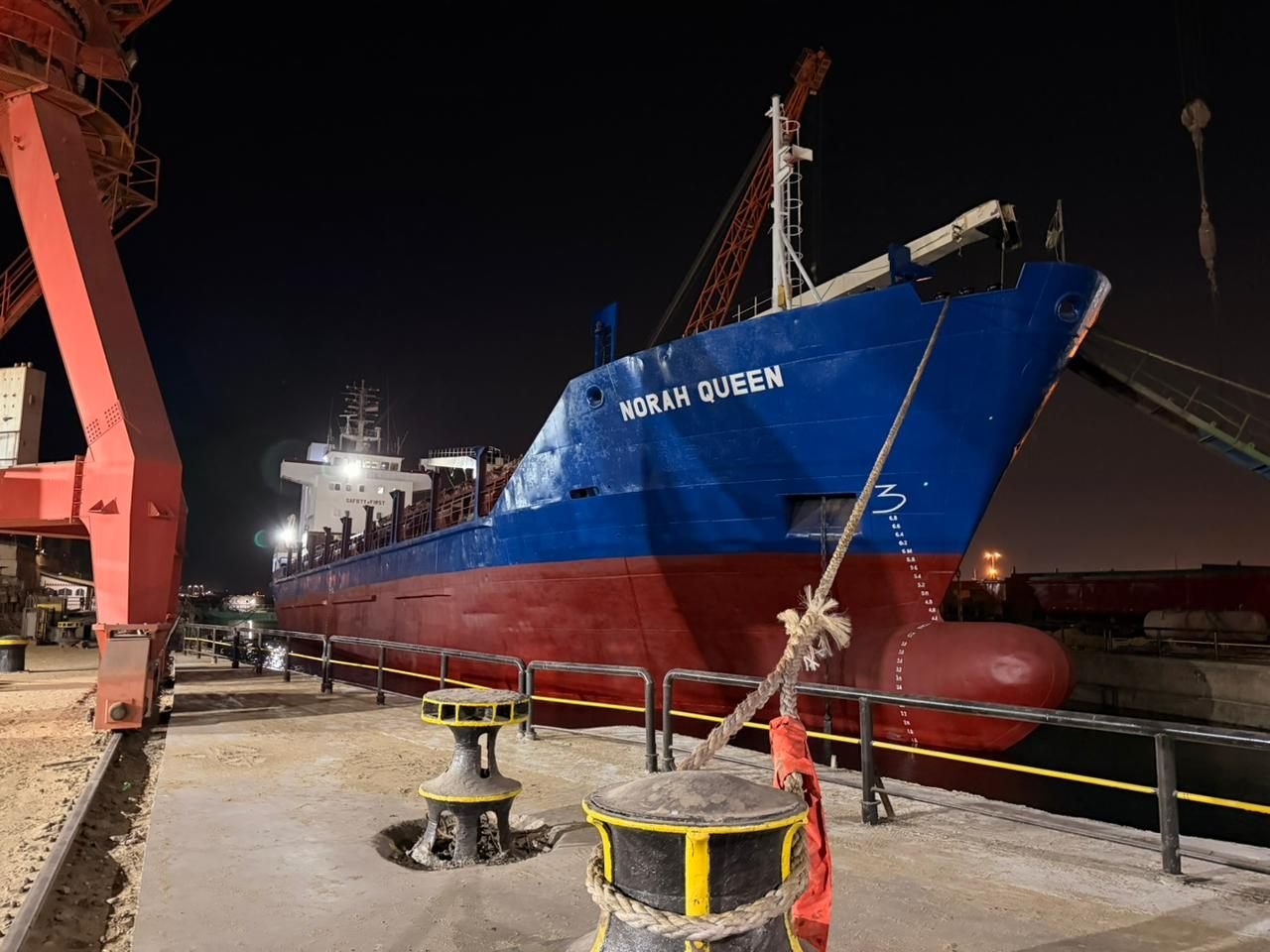 MV Norah Queen alongside at night, bow and forward cranes
